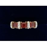 A 9 carat gold ring set orange stones and bands of chip diamonds, size O, 2.9g