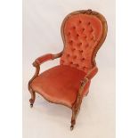 A Victorian mahogany button upholstered armchair on carved scrollwork supports