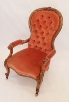 A Victorian mahogany button upholstered armchair on carved scrollwork supports