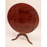 A Georgian mahogany tilt top circular occasional table on turned column and triple supports