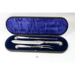A silver handled three piece carving set with scollover terminals, cased, Sheffield 1908 by Harrison