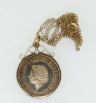 A 9ct gold scroll top coin mount on a fine 9ct gold chain containing a 1977 Silver Jubilee