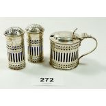 An Edwardian three piece silver condiment set, mustard and pair of peppers with pierced decoration