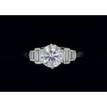 A platinum set diamond ring, the central brilliant cut stone 1.2 cts flanked by two baguette cut