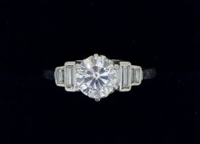 A platinum set diamond ring, the central brilliant cut stone 1.2 cts flanked by two baguette cut