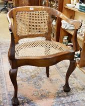 An early 20th century corner caned chair with claw and ball feet