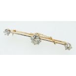 An 18 carat and platinum gold bar brooch set central diamond (1.48cts) flanked by two further