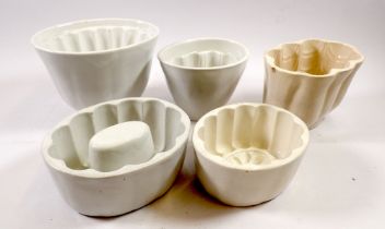 A Victorian pottery fish jelly mould, a Booths mould and three other jelly moulds