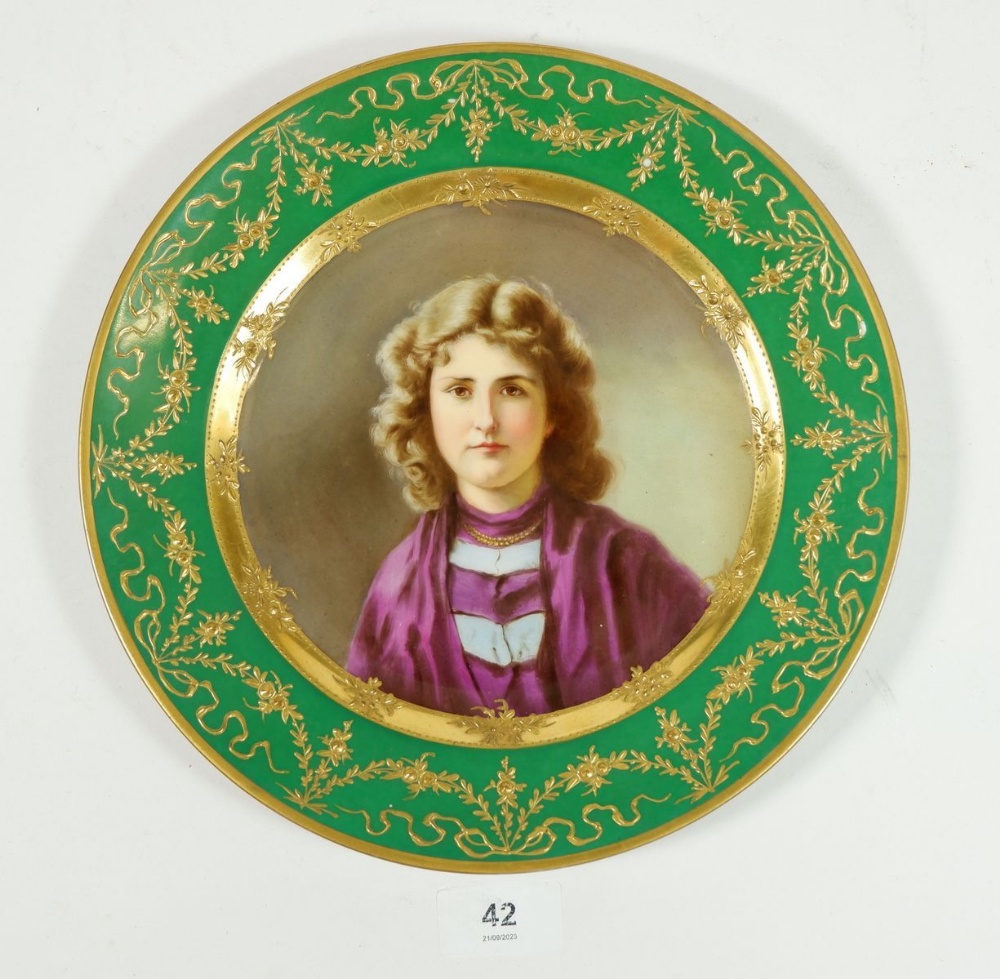 A Vienna plate painted portrait of a young woman in green and gilt border, 24.5cm