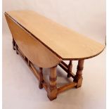 A good quality large Brynhall oak dropleaf oval dining table on turned column supports 226x145x76cm