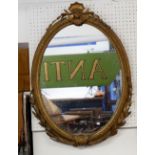 A 19th century oval gilt framed mirror with shell surmount and applied leaves and husks, 73 x 54cm