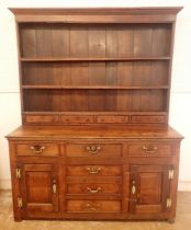 A Georgian oak Welsh dresser, the three tier back with four spice drawers all over base with