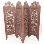 An Indian folding carved wooden screen 182cm tall