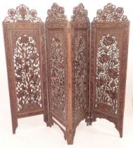 An Indian folding carved wooden screen 182cm tall