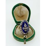An antique 18 carat gold and enamel ring silver set with old cut diamonds, the central Fleur De