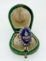 An antique 18 carat gold and enamel ring silver set with old cut diamonds, the central Fleur De