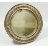 A Victorian silver easel mirror with embossed scrollwork and floral decoration, 28cm diameter,