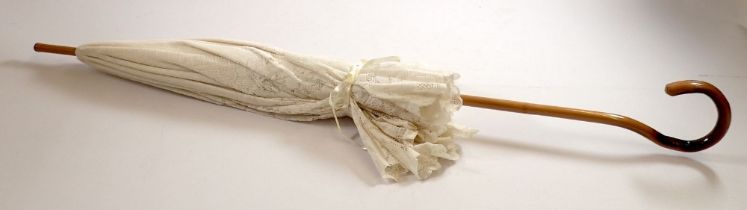 An Edwardian style white lace wedding parasol with bamboo handle