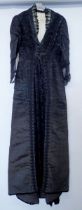 A Victorian black satin dress with lace collar and sleeves plus panel of beading and braiding