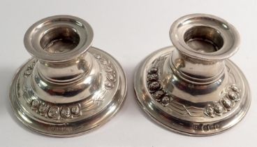 A pair of silver squat candle holders with embossed flowers, Birmingham 1909 by James Deakin, 4cm