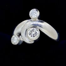 A privately commissioned 18 carat white gold ring with three inclusion set diamonds in scrollwork