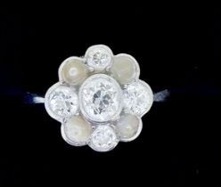 A platinum set diamond and pearl cluster ring, the central diamond approx 0.5 carats, size M, the