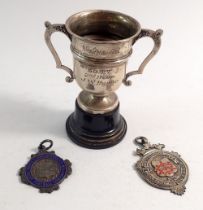 A silver miniature sports trophy, Sheffield 1939 and two silver football medals