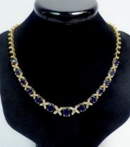 A 14k gold necklace set thirteen graduated sapphires interspersed with diamond crosses, on fancy