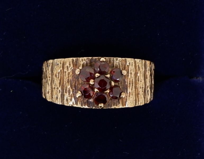 A vintage 9 carat gold garnet cluster ring on textured band, size M to N, 3.7g