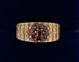 A vintage 9 carat gold garnet cluster ring on textured band, size M to N, 3.7g