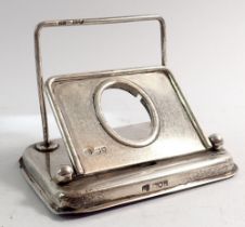 A silver letter rack with hinged photograph frame to front, London 1902 by Betjemann Brothers