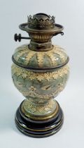 A late 19th century Doulton Lambeth oil lamp, the green mottled glaze moulded in relief with