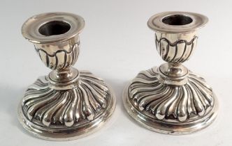 A pair of Victorian spiral embossed silver squat candlesticks, London 1886 by Horace Woodward & Co.