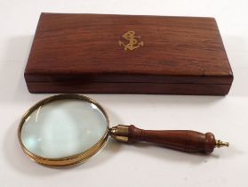 A brass magnifying glass in wooden box