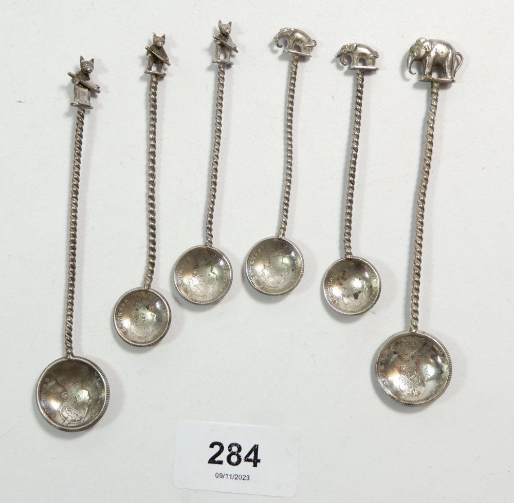 Six Indian white metal small spoons with animal terminals and coin bowl