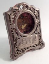 An Edwardian silver pocket watch stand with pierced floral decoration and embossed panel of cherubs,
