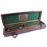 A brown leather and oak gun case, green baize lined interior fitted for 30 ins barrels, George. H.