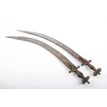 Two similar Indian short bladed Tulwars, both blades approximately 25 ins and curved single edged,