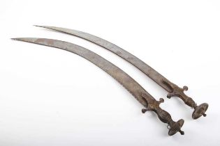Two similar Indian short bladed Tulwars, both blades approximately 25 ins and curved single edged,