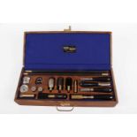 Cased William Powell 12 bore shotgun cleaning kit including chamber brush, choke gauge, cartridge