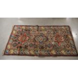 A worn geometric rug, losses to the surface, with a bold geometric coloured design, 187cm x 103cm AF