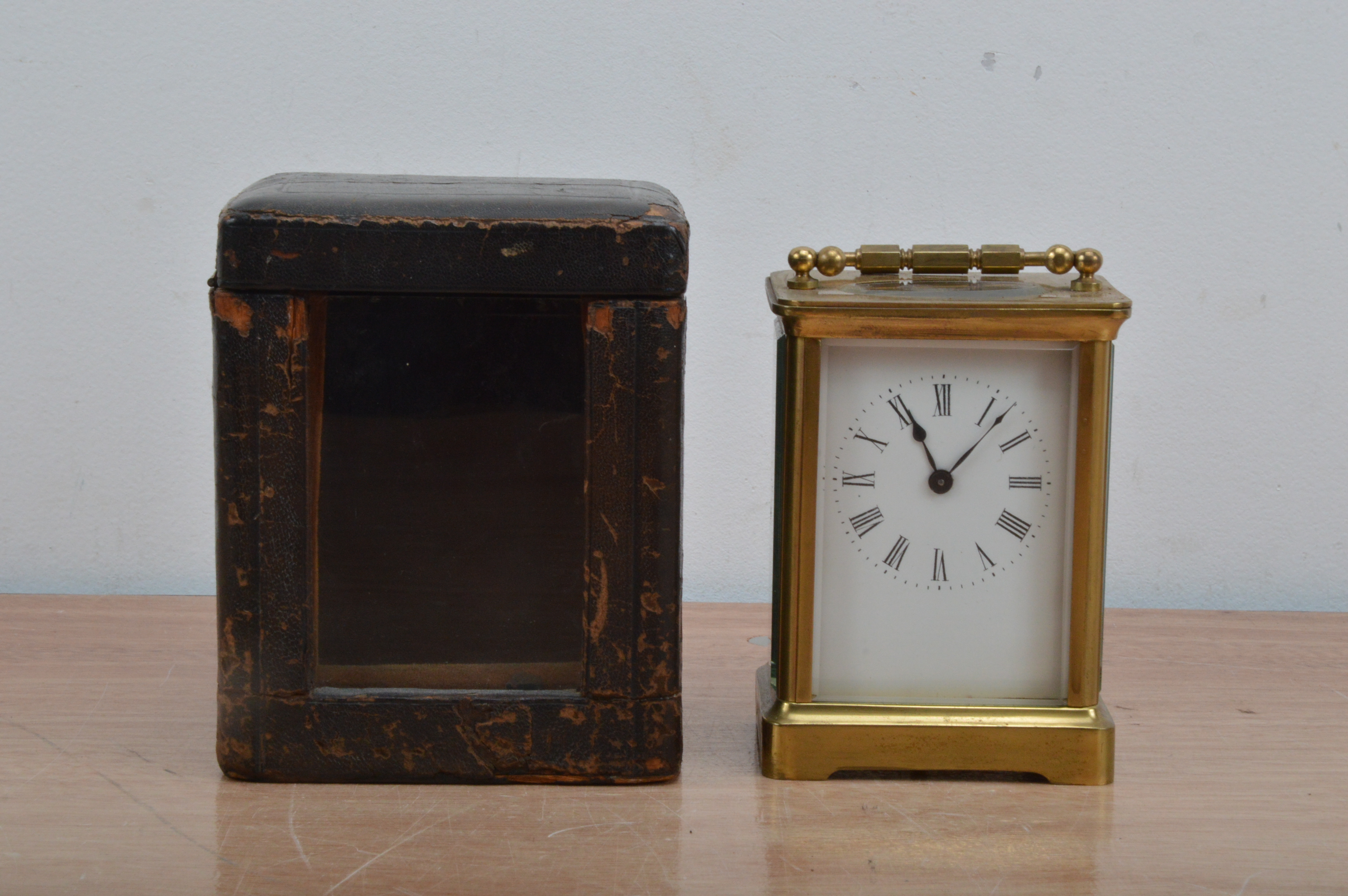 An early 20th century brass carriage clock, enamel dial with roman numerals, total height 12cm, with