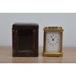 An early 20th century brass carriage clock, enamel dial with roman numerals, total height 12cm, with