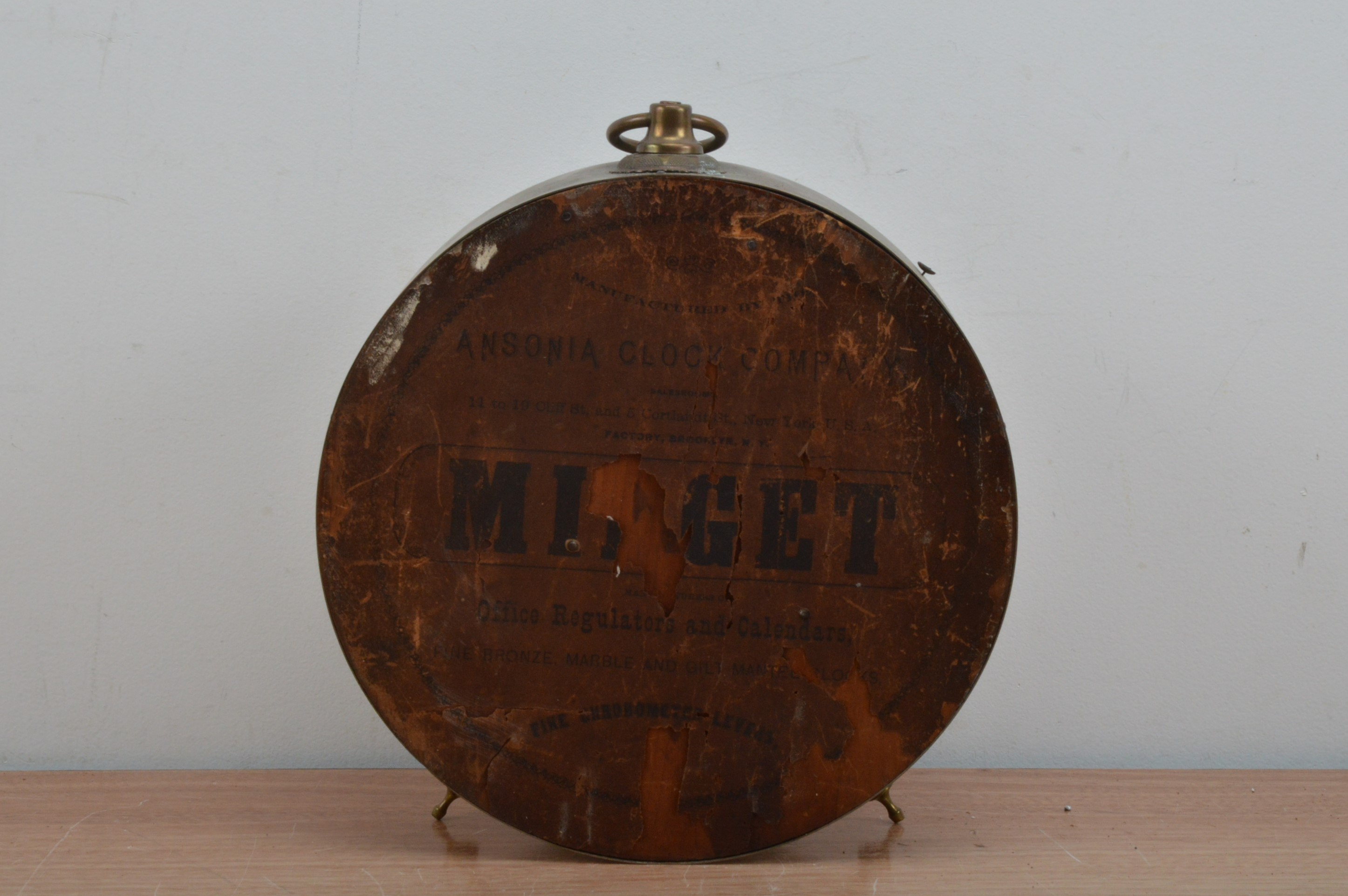 An Ansonia Clock Company American copper and brass circular clock, raised on two feet with a - Image 2 of 2