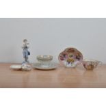 A collection of continental ceramics, comprising a small figurine of a boy playing a musical