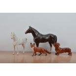 Four ceramic animals, comprising a Beswick fox and sausage dog, a Sylvac white horse and a large