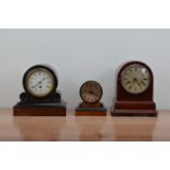 Three domed wooden cased mantle clocks, all dials with Roman numerals, the larger two with