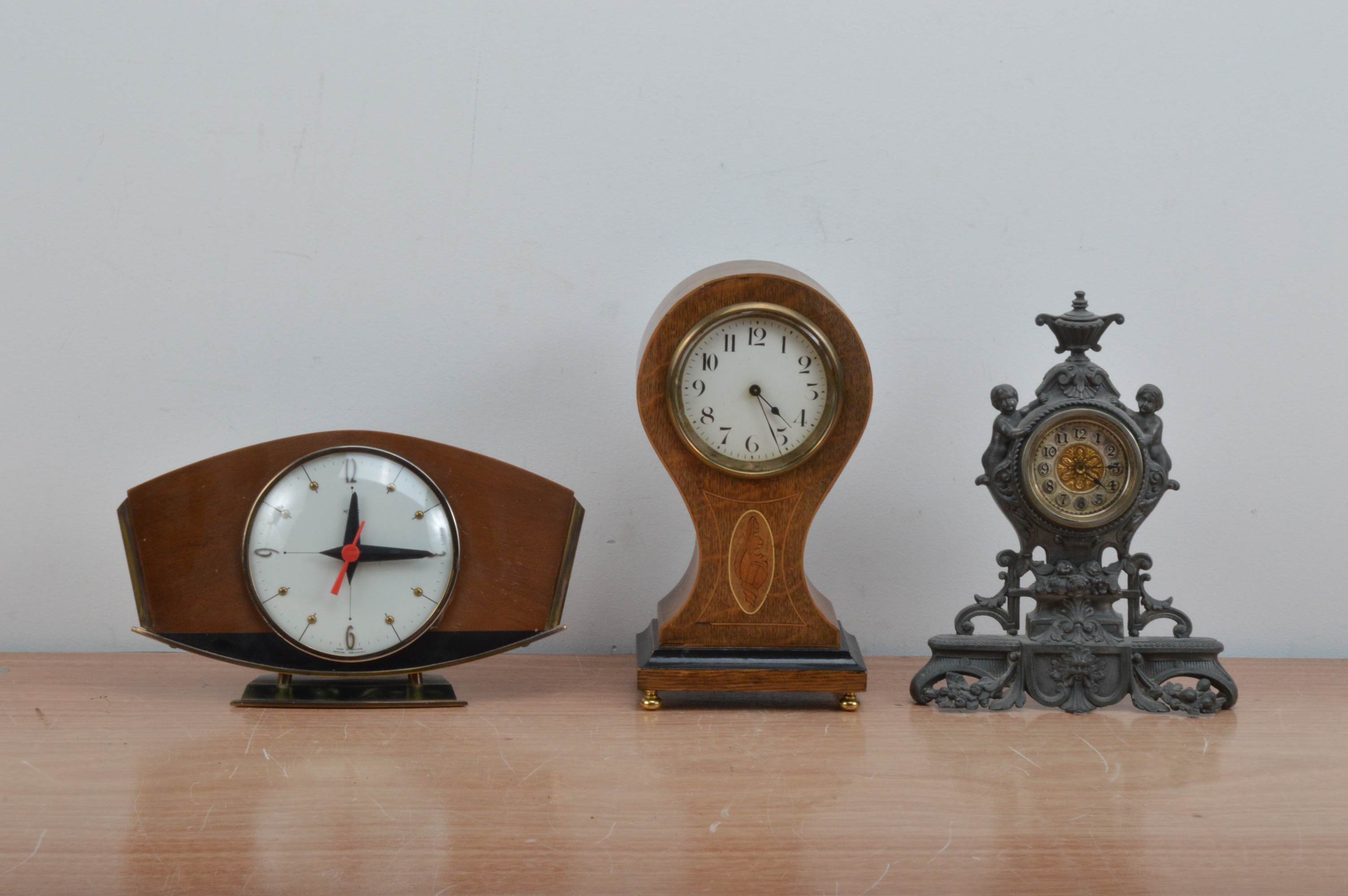 Three clocks, of differing styles, on a mahogany cased classical style mantle clock, the dial with