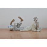 A Lladro ceramic figure of a clown, lying down with a balloon by its foot, marked to the