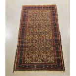 A middle-eastern wool on wool rug, brown, red and yellow geometric design, fringes, some wear and